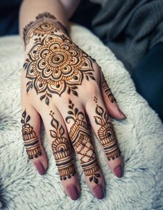 a woman's hand with henna tattoos on it