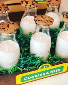 cookies and milk are in glass bottles on the table