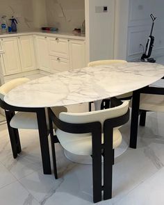 a marble dining table with four chairs around it