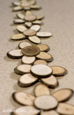 wooden slices are arranged in a long line on the floor, with one penny at the end