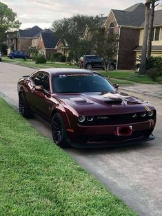 a red sports car parked on the side of a road next to a street sign