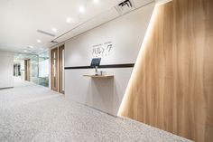 an empty room with a laptop on the desk and wooden partition in the wall behind it