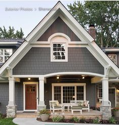 a house with a pool in front of it and two chairs on the lawn outside