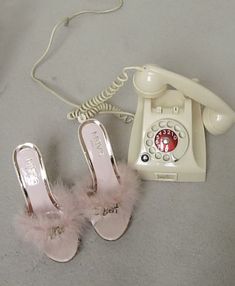 a pair of pink shoes sitting next to an old phone