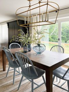 a dining room table with chairs and vases on it