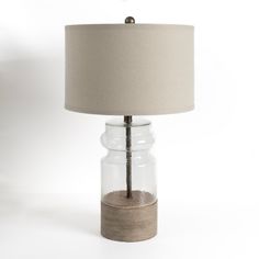 a table lamp with a wooden base and glass jar on the bottom that has sand in it