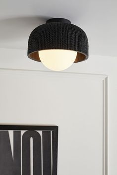 a black light fixture hanging from the ceiling in a room with white walls and flooring