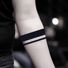 a woman's arm with a black and white striped tattoo on her left forearm