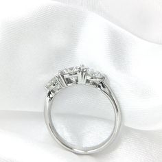 three stone diamond ring on white fabric