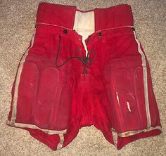 an old pair of red pants sitting on the floor