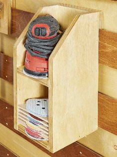 a pair of shoes in a wooden shoe rack on the wall next to wood planks