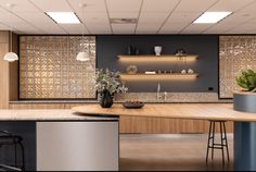 a modern kitchen with an island and counter tops in the center is lit by recessed lights