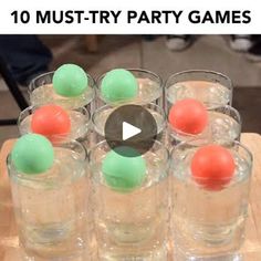 several glasses with balls in them sitting on a wooden table next to an orange and green ball