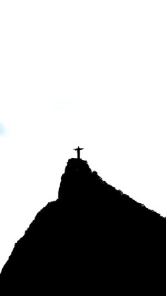 a person standing on top of a hill with a cross in the middle of it