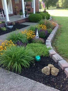 a front yard garden with flowers and rocks