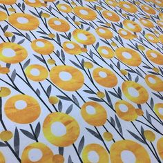 yellow and gray flowers on white fabric with black stems in the center, all over