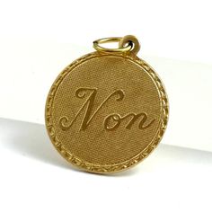 a gold medal with the word mom engraved on it