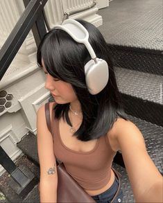 a woman with headphones sitting on some steps