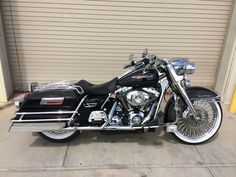 a black motorcycle parked in front of a garage