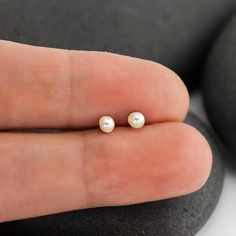 These solid 14K tiny stud pearl earrings are perfect for a tiny bit of regal glow or for second piercings. They feature genuine lovely 3mm pearls that are ringed with the thinnest thread of 14K. The post is centered on the back of the 14K gold disc and matching 14K earring backs are included. Reliable and effortless - exactly the kind of sparkle that I love to add to my day. Second Piercings, Second Hole Earrings, Solid Gold Bangle, Herkimer Diamond Earrings, Hammered Wedding Bands, Black Beads Mangalsutra, Black Beads Mangalsutra Design, Ruby Earrings Studs, Second Piercing