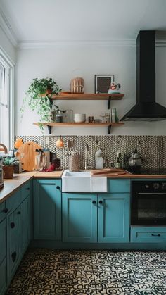 a kitchen with blue cabinets and black appliances