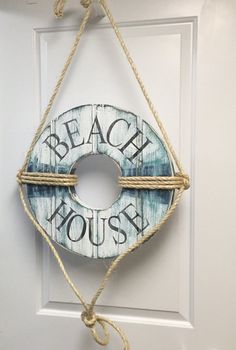 a door hanger that says beach house hanging on the side of a white door