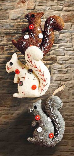 three stuffed animals sitting on top of each other in front of a stone wall with red eyes