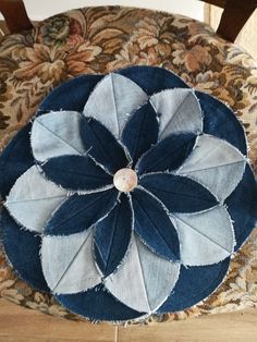 a blue and white patchwork flower on a chair cushion