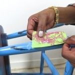 a woman is painting a blue chair with pink and green paint