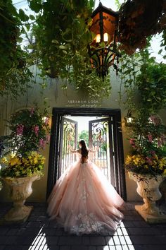 a woman standing in front of a doorway wearing a pink dress with flowers on it