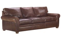 a brown leather couch sitting on top of a white floor