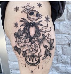 a woman's thigh with a skeleton and flowers tattoo on it