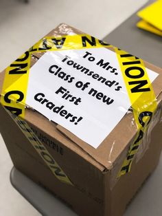 a cardboard box with a sign on it that says, to mitt township's class of new first graders