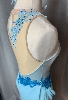 a mannequin wearing a blue and white dress with beading on the bust