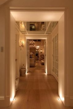 the hallway is lit up with warm lighting and features recessed lights on both sides