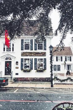 a truck parked in front of a white building with christmas decorations on it's windows