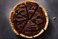 a chocolate tart with one slice cut out and the rest on top of it