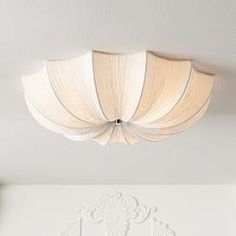 the ceiling light is hanging from the ceiling in this bedroom with white walls and furniture