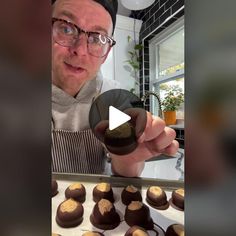 a man in glasses is pointing to some chocolates