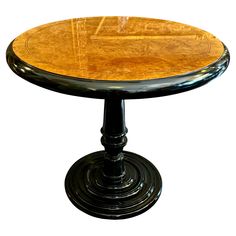 a round wooden table with black pedestals and wood grain on the top, against a white background