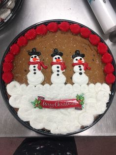 a cake decorated with frosting and three snowmen