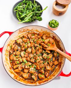 a pan filled with chicken and broccoli on top of a white countertop