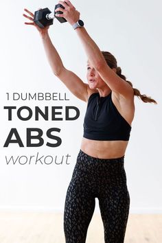 a woman in black top and patterned leggings with dumbbell tone abs workout