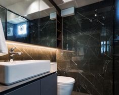 a bathroom with black marble walls and flooring