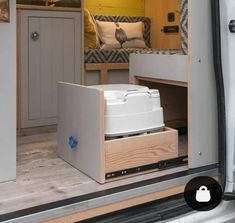 the interior of a camper with its door open and storage compartment in place on the floor