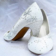 a pair of white wedding shoes with snowflakes on the toes and heels are shown