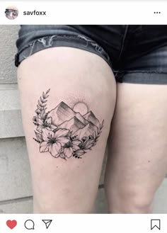 a woman's thigh with flowers and mountains on it