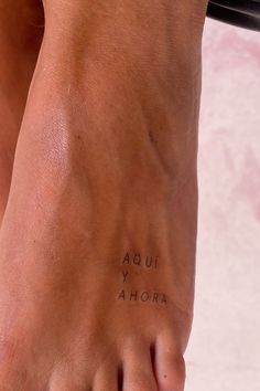 a woman's foot with the words aoui y ahora written on it