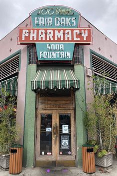 the front entrance to a restaurant with green awnings and red lettering that reads far oaks pharmacy soda fountain