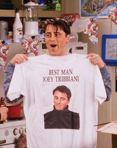 a man holding up a t - shirt with the words best man, joey tribbiani on it